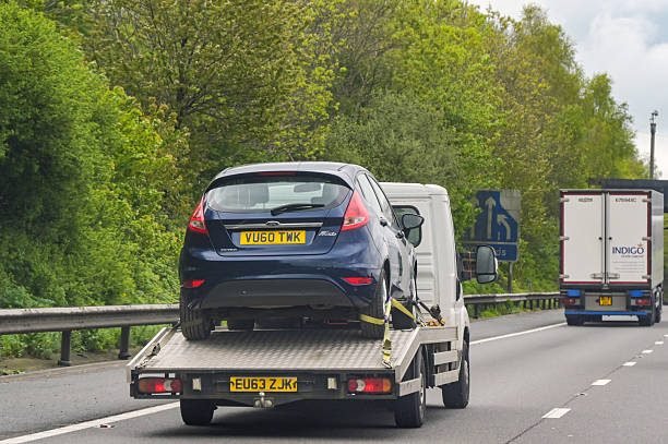Recovery truck carrying a blue Ford Fiesta along a Bedfordshire dual carriageway