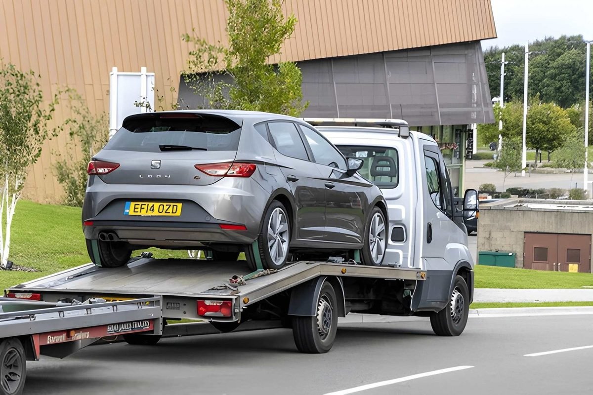 Grey SEAT Leon secured on a recovery truck ready for transport